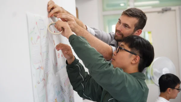 Middle school student attaching notes to wall in character education class at wuhan yangtze international school.