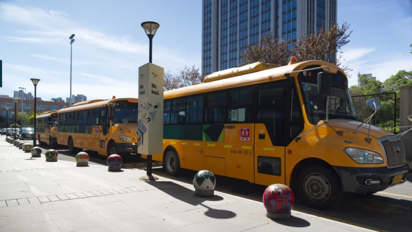 School buses parked in front of the academic building at Wuhan Yangtze International School.