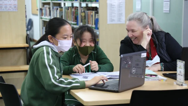 wuhan yangtze international school secondary middle school teacher helping two students in the library