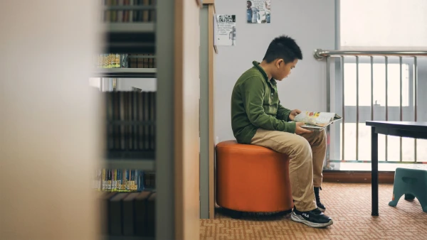 young male student reading a book in wuhan yangtze international school campus library