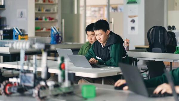 two male students inside wuhan yangtze international school learning robotics