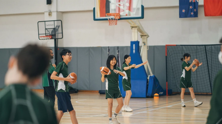 diverse students at wuhan yangtze international school learning american football in the gym
